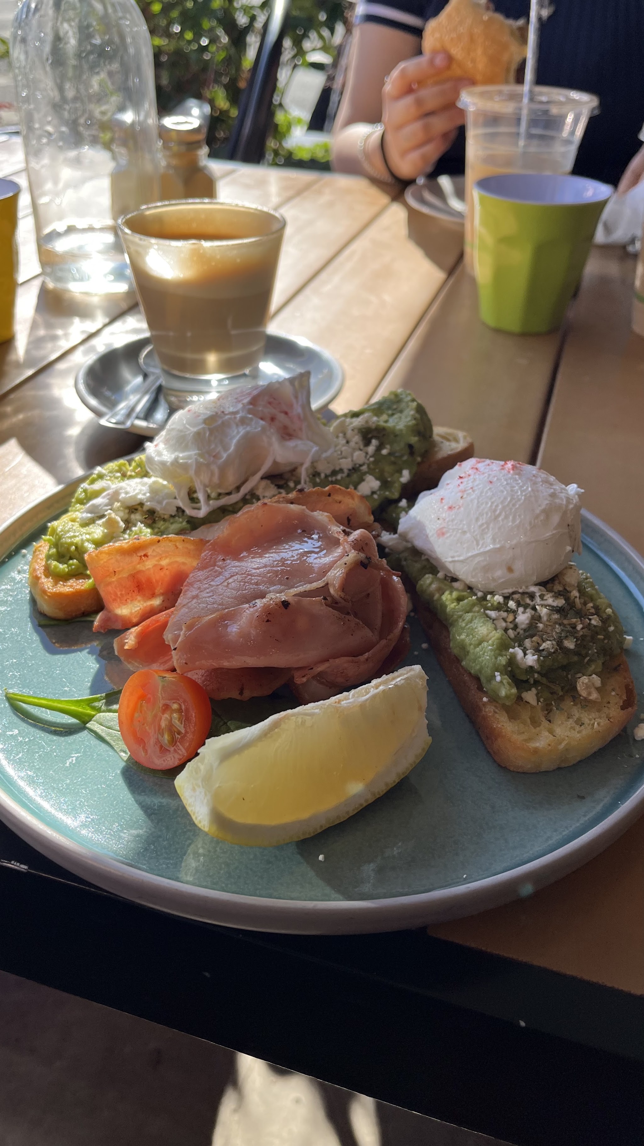 Brunch plate with poached eggs, avocado and bacon, served in the sun